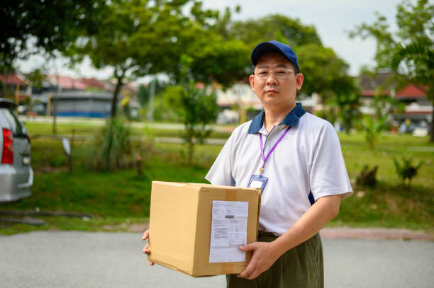 istock Asian deliveryman holding cardboard box 1277166713
