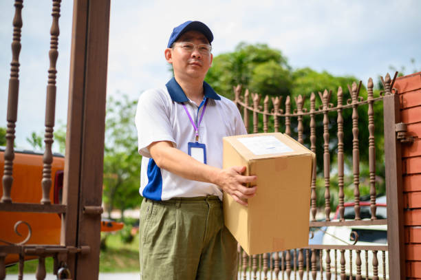 istock Asian deliveryman holding cardboard box 1277166722