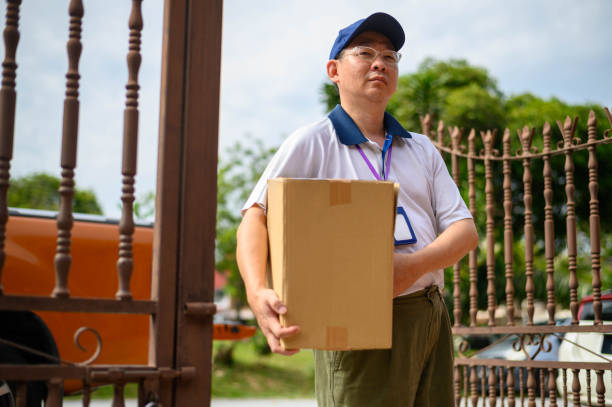 istock Asian deliveryman holding cardboard box 1277166738