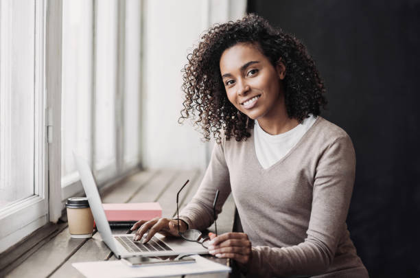 Young woman student using laptop at cafe