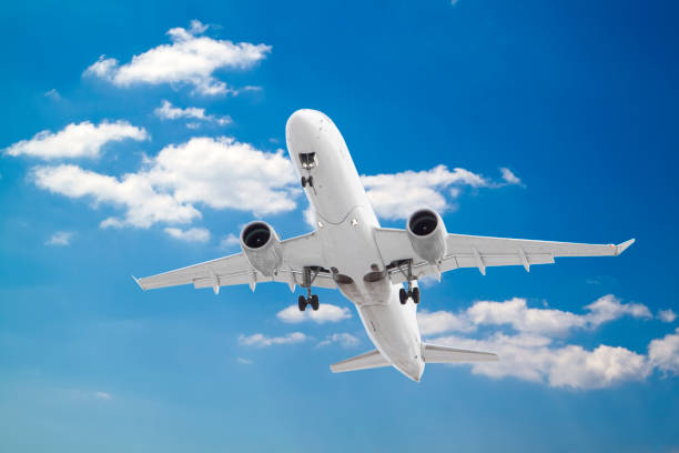 istock white passenger plane has released its landing gear and is coming in to land with background of white clouds and blue sky 1277169963