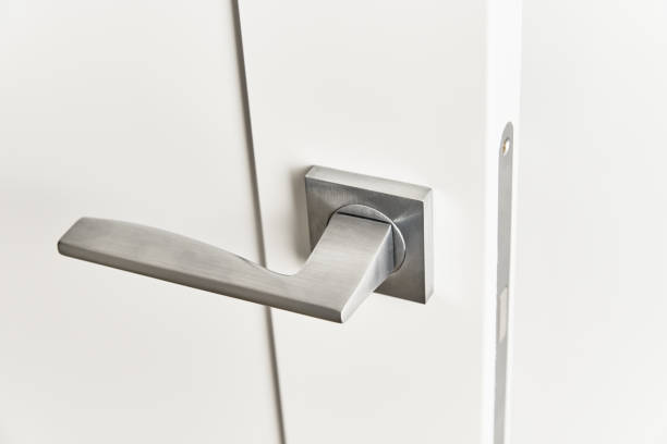 istock Silver door handle on a white door.  Furniture accesories, interior element 1277170459