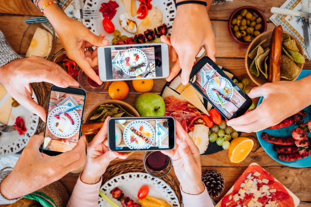 toppvy av grupp människor under julnatten tar mat och rätter bild med smartphone alla tillsammans - begreppet fest fest tradition med familj och vänner och teknik - mat fotografier bildbanksfoton och bilder
