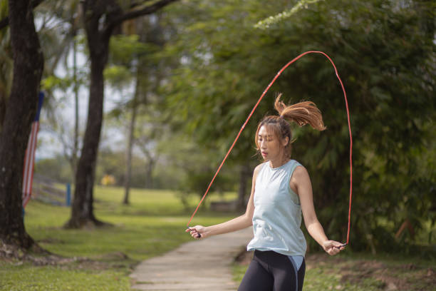 Asia Chinese  women keeps fit using jumping rope in the public park. stock photo