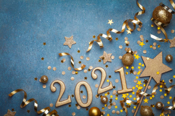 urlaub hintergrund mit goldenen weihnachtsdekorationen und neujahr 2021 zahlen und konfetti top-ansicht. - 2021 stock-fotos und bilder