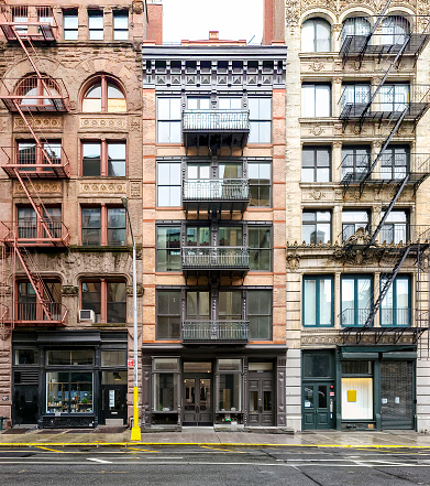 Exterior fire escape staircases on New York City buildings during summer day