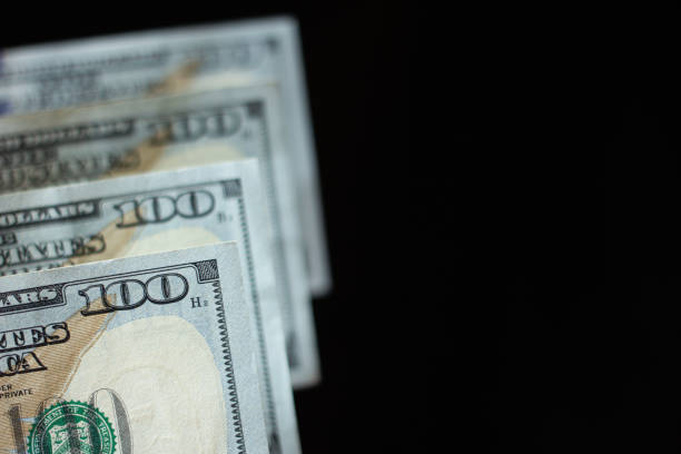 istock Hundred dollar bills isolated and aligned with blur.  Business and financial abundance and USD american dollar concept.  Black isolated background. 1277175708