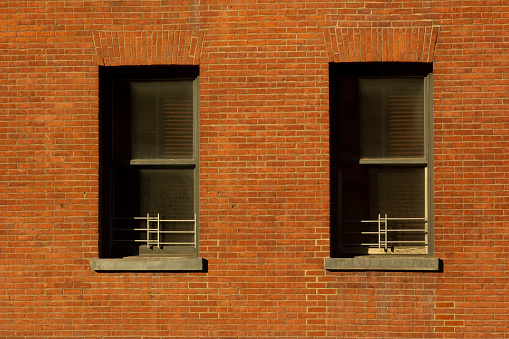 Two windows on a brick building façade in Tribeca, New York City.