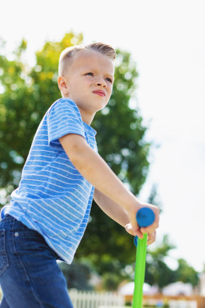 istock Young Male Child Looking into the Distance While Standing on a Scooter 1277176585