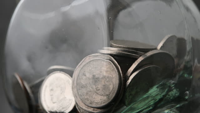 Thai baht money coins in glass bottles money saving saving video rotation 4k