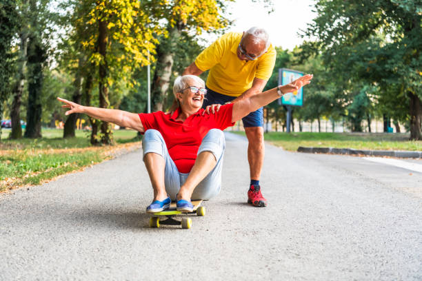 istock Active senior couple enjoying day together while riding skateboard in autumn park 1277179042