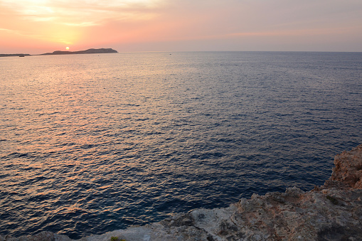 Sunset over Mediterranean Sea, view from the cliff on Ibiza island.