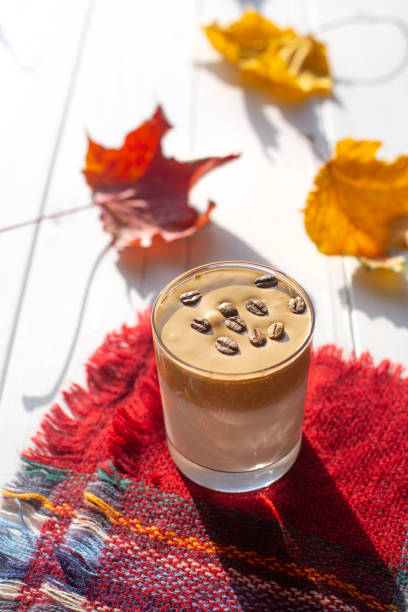 istock Traditional Korean drink, Dalgona coffee in a glass with coffee beans on a white boards background. Autumn breakfast. 1277184810