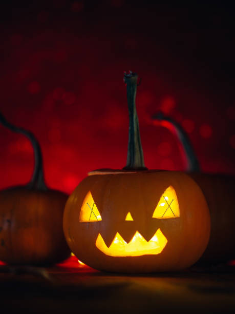istock Halloween pumpkin lantern on red dark glowing background 1277186507