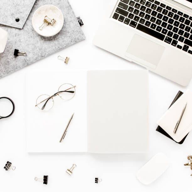 istock Home office workspace frame with laptop, clipboard, notebook and accessories on white background. Flat lay, top view 1277186638