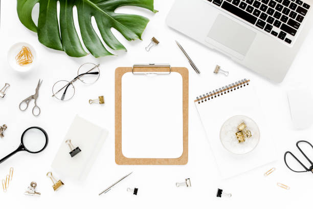 istock Home office workspace mockup with laptop, tropical leaves Monstera, clipboard, notebook and accessories on white background. Flat lay, top view 1277187476