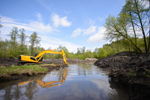 Vista al campo de un sistema de canales de drenaje y excavadora de trabajo photo