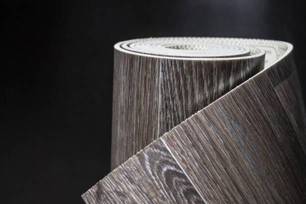 istock Black linoleum in a roll on a black background. 1277188849