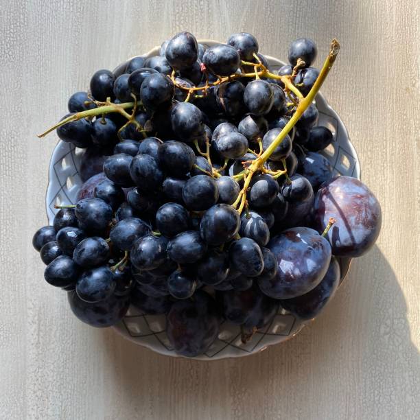 istock Close-up image of black grapes and ripe plums 1277189387