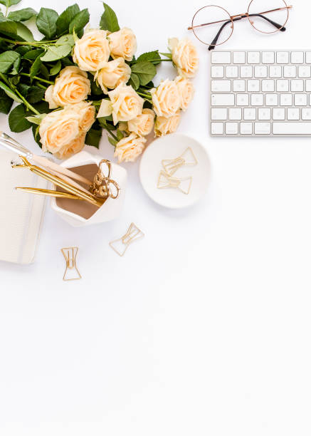 istock Female workspace with computer, roses flowers, golden accessories, diary, laptop, glasses on white background. Flat lay women's office desk. Top view 1277189423