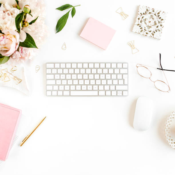 istock Flat lay women's office desk. Female workspace with computer, pink peonies bouquet, accessories on white background. Top view feminine background 1277189480