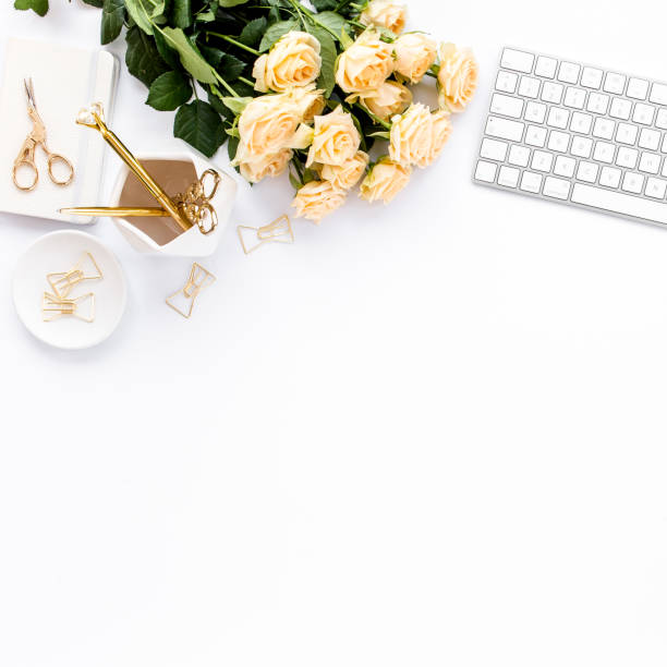 istock Female workspace with computer, roses flowers, golden accessories, diary, laptop, glasses on white background. Flat lay women's office desk. Top view 1277189528