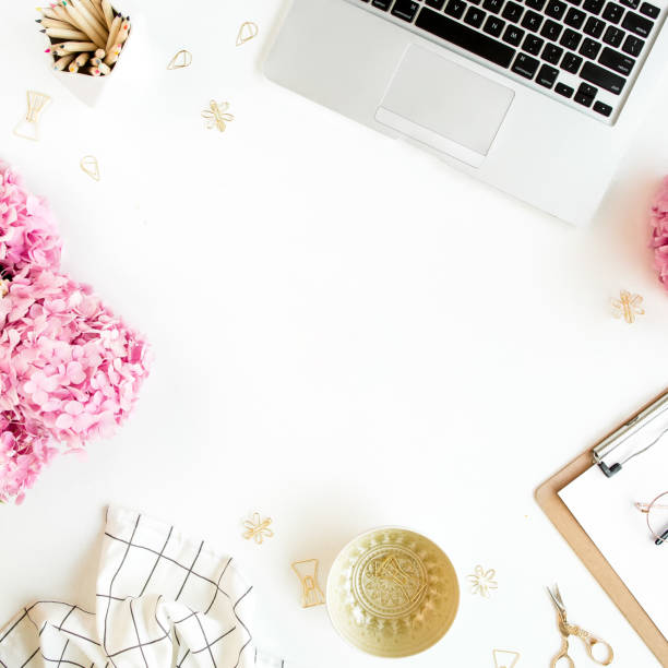 istock Workspace with clipboard, laptop, bouquet hydrangea, accessories on white background. Stylized women's desk. Flat lay. Top view 1277191787