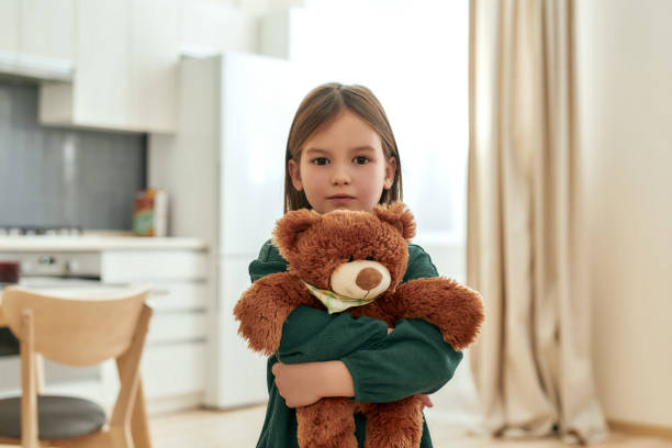 istock A small cute girl tightly holds her fluffy toy while looking into a camera 1277192036