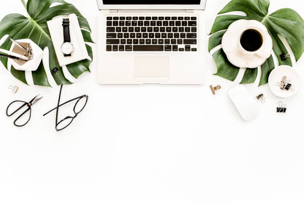 istock Home office workspace mockup with laptop, tropical leaves Monstera, clipboard, notebook and accessories on white background. Flat lay, top view 1277192340
