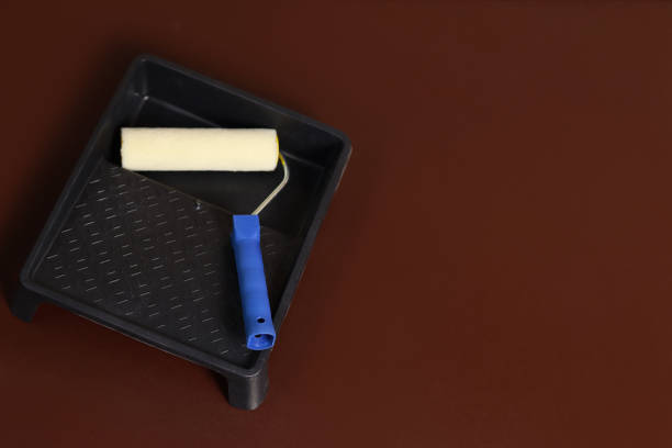 istock Black paint tray and roller on a dark brown background, copy space for text 1277193477