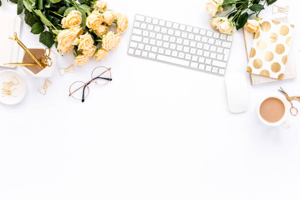 istock Female workspace with computer, roses flowers, golden accessories, diary, laptop, glasses on white background. Flat lay women's office desk. Top view 1277193545