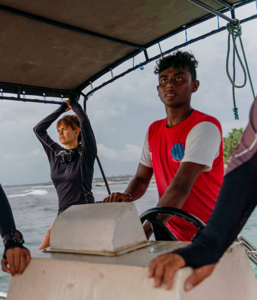 jovem capitão, sri lanka, controlar o barco com um grupo de mergulhadores a caminho do oceano. - men latin american and hispanic ethnicity southern european descent mature adult - fotografias e filmes do acervo