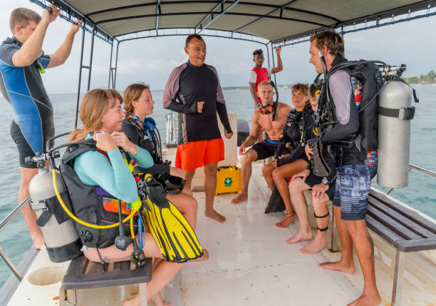 mature man - chief of the diving team instructing a group of divers, men, and women aboard a boat before diving in the ocean. - men latin american and hispanic ethnicity southern european descent mature adult imagens e fotografias de stock