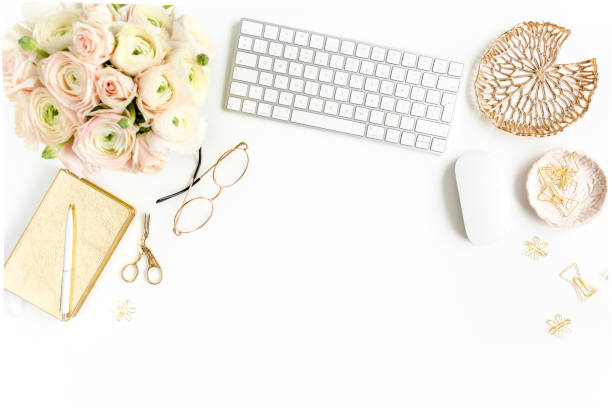 istock Stylized women's home office desk. Workspace with computer, bouquet ranunculus and roses, clipboard on white background. Flat lay. Top view 1277195622