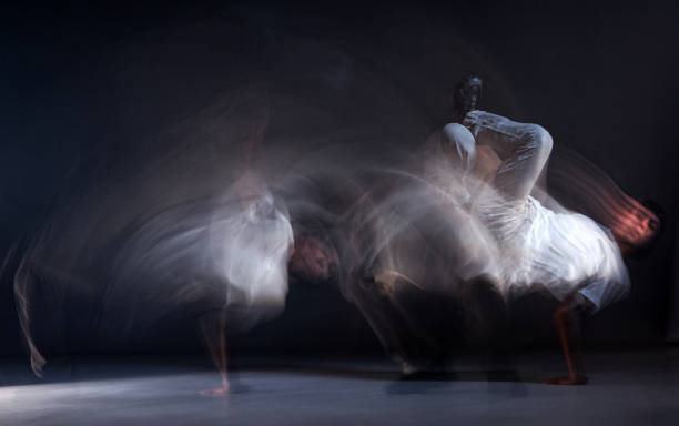 istock Guy breakdancer dancing hip-hop on the floor in studio on black background. Dance school poster. Long exposure shot 1277195763