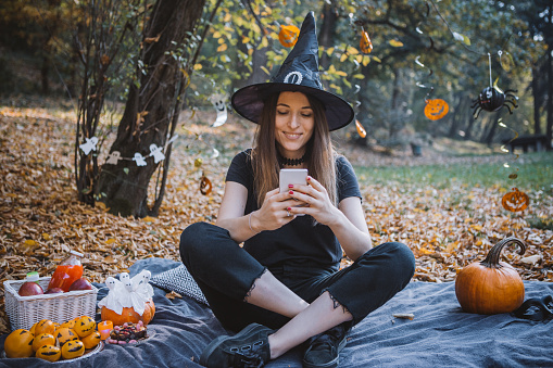 Women at park on picnic during Halloween.