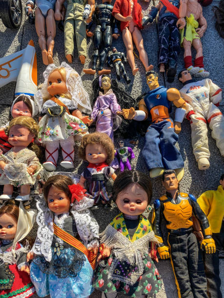 Valencia, Spain - September 27, 2020: Group of dolls and action figures on the floor for sale in second hand market outdoors. Like in many other cities of the country here also exists 'rastros' or places were used and vintage items are sold for very low prices