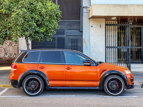 Valencia, Spain - September 27, 2020: An orange Volkswagen car model Touareg parked in the street. It is produced by the German automaker since 2002 at the Volkswagen Bratislava Plant. The vehicle was named after the nomadic Tuareg people, inhabitants of the Saharan interior in North Africa