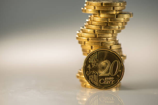 istock one stack of golden coins and one twenty euro cent coin lie on a light background. 1277199977