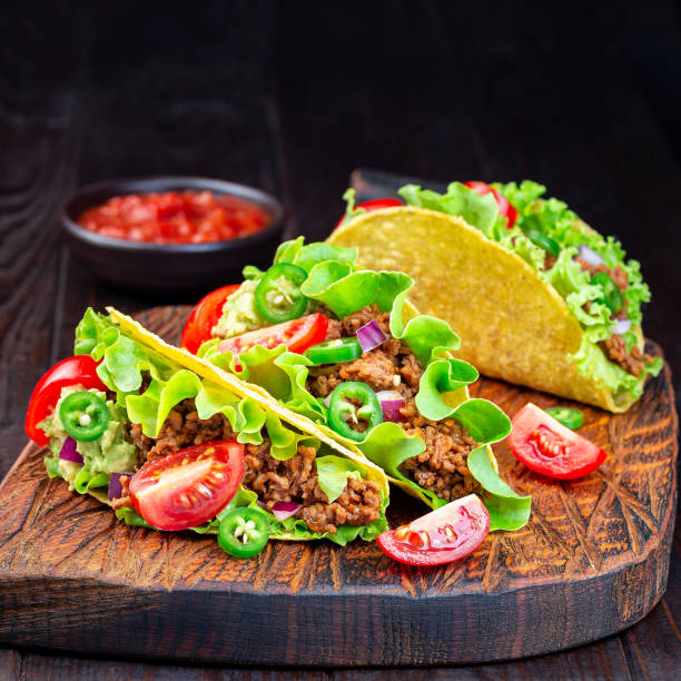 istock Taco with ground beef meat,  mashed avocado, tomato, lettuce, red onion and jalapeno pepper, square 1277200278