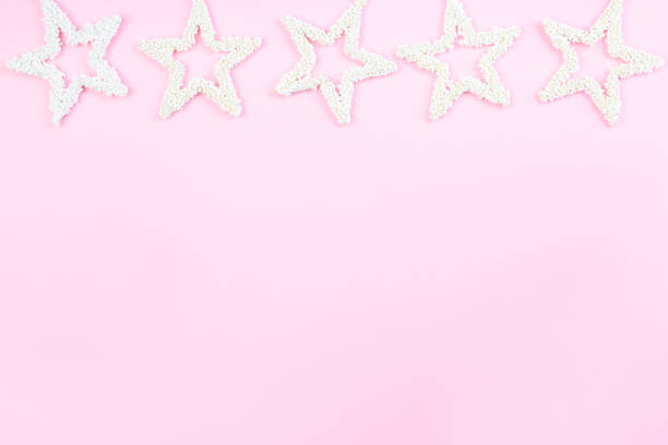 istock Christmas composition border with white stars on pink background, horizontal, copy space, top view 1277200294