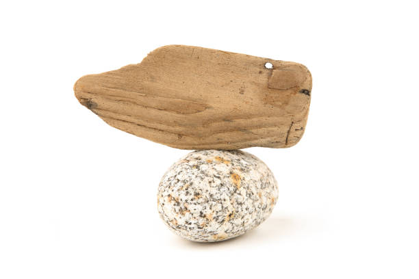 istock Sea driftwood sign label on oval pebble isolated on white background. 1277202918