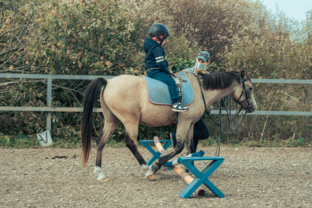 Boy with a horse. Hippotherapy for young children is the prevention of spinal diseases, as well as therapy after many serious diseases