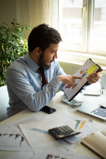 istock Business accounting concept, Business man using calculator with computer laptop, budget and loan paper in office. 1277204347