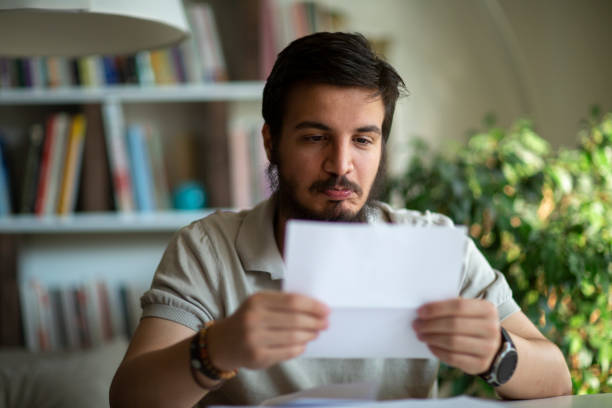 istock Angry stressed man opening envelope reading bad news in letter 1277205625