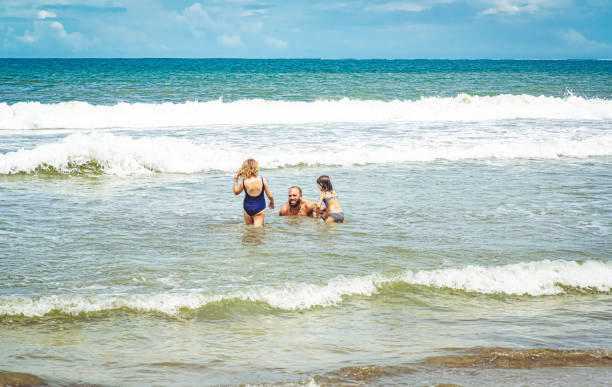 Family on an idyllic beach in Costa Rica Scenic ocean in Costa Rica with family enjoying the waves family beach vacations travel stock pictures, royalty-free photos & images