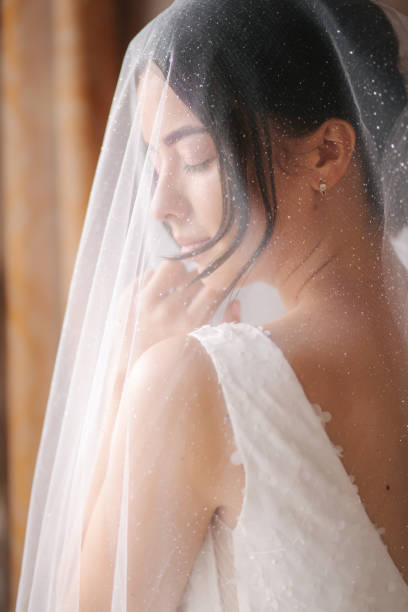 istock Bride on the veil stand by the window and wait for the goom 1277207470