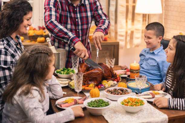istock Young father carving traditional stuffed turkey for Thanksgiving dinner 1277207563