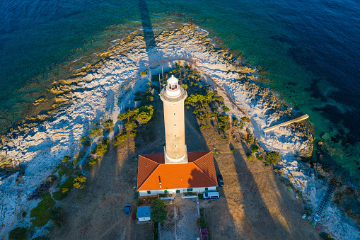 Aerial view of lighthouse tower of Veli Rat on the island of Dugi Otok, Croatia in early morning, Adriatic sea in background