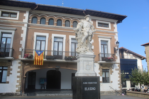 Getaria, Spain – September 11, 2020: Juan Sebastian Elcano statue and Getaria Town Hall. It’s visible an independentist catalan flag, since 11 September is the Catalan National Day.